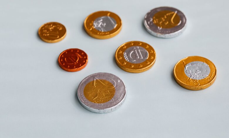 From above of different size chocolate euro coins placed on white surface