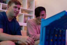 Two men sitting indoors, enjoying and playing a fun board game together.