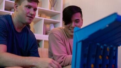 Two men sitting indoors, enjoying and playing a fun board game together.