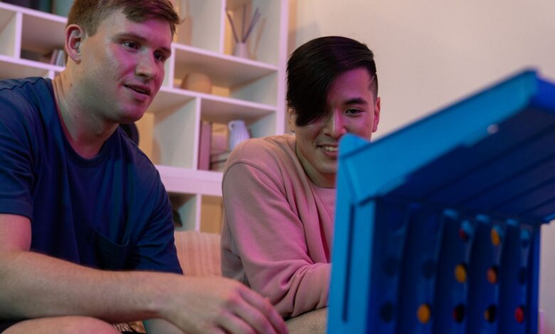 Two men sitting indoors, enjoying and playing a fun board game together.