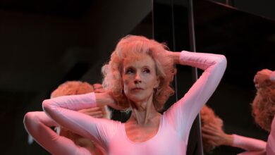 A captivating image of a senior woman gracefully posing in front of a mirror indoors.