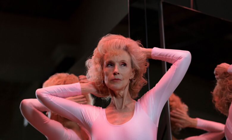 A captivating image of a senior woman gracefully posing in front of a mirror indoors.