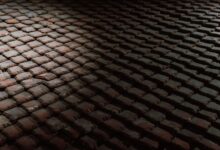 High contrast image of rooftop tiles in shadow, creating a moody textural pattern.
