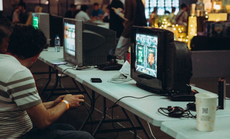 Adults enjoying a retro gaming event with CRT televisions and consoles, creating a nostalgic atmosphere indoors.