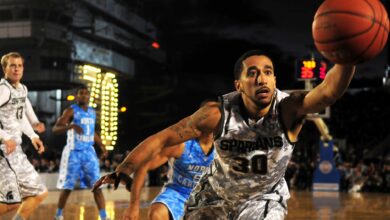 Intense basketball game with athletes in action on an outdoor court during nighttime.