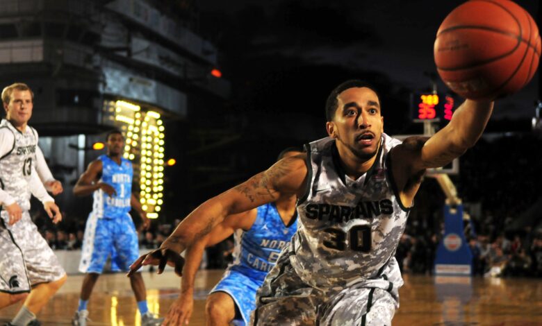 Intense basketball game with athletes in action on an outdoor court during nighttime.