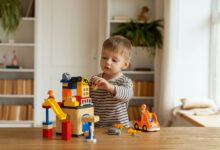 Young child playing creatively with building blocks indoors, fostering imagination and fun.