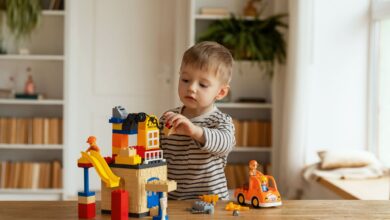 Young child playing creatively with building blocks indoors, fostering imagination and fun.