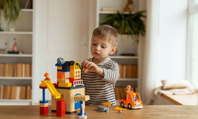 Young child playing creatively with building blocks indoors, fostering imagination and fun.