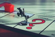 Close-up of a Monopoly board with a token and house, capturing classic board game elements.