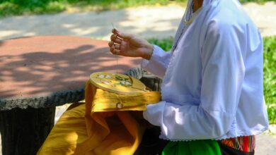 Vietnamese woman engaging in traditional embroidery outdoors in Hue, Vietnam.