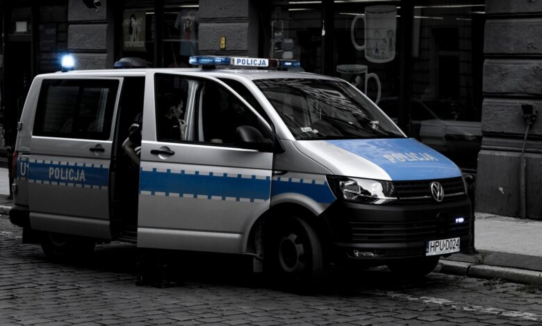 A police van parked on a cobblestone street in an urban setting.
