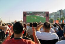 Crowd watching a soccer game on a large screen outdoors in Istanbul, Türkiye.