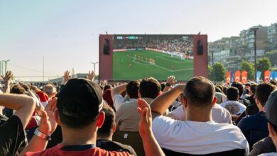 Crowd watching a soccer game on a large screen outdoors in Istanbul, Türkiye.