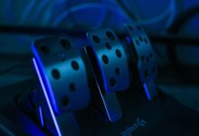 Detailed shot of gaming pedals illuminated by blue light, perfect for racing simulation setups.