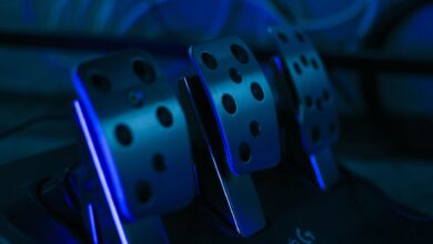 Detailed shot of gaming pedals illuminated by blue light, perfect for racing simulation setups.