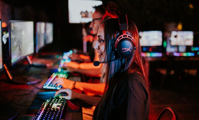 People enjoying a late-night video gaming session with headsets and RGB keyboards.