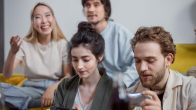 Group of diverse friends having fun playing video games in a relaxed indoor setting.