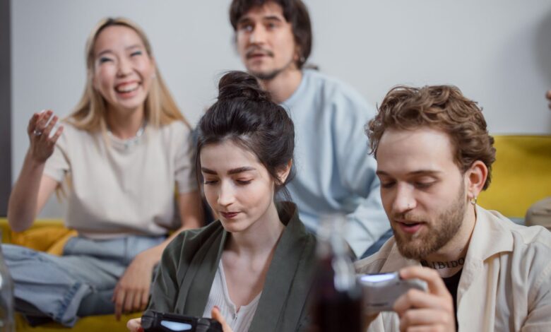 Group of diverse friends having fun playing video games in a relaxed indoor setting.