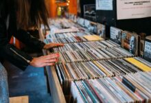 Woman browsing vinyl records in a cozy vintage music store, enjoying leisure time.