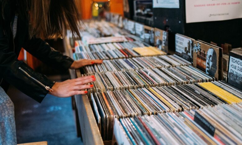 Woman browsing vinyl records in a cozy vintage music store, enjoying leisure time.