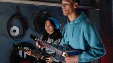 Two friends playing an interactive guitar video game indoors, showcasing joy and teamwork.