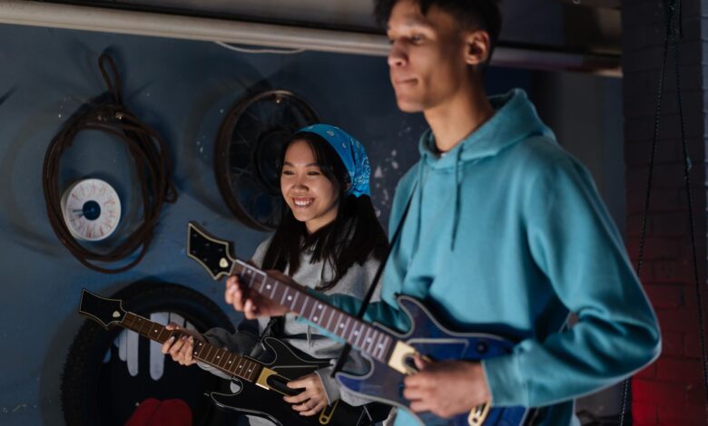 Two friends playing an interactive guitar video game indoors, showcasing joy and teamwork.