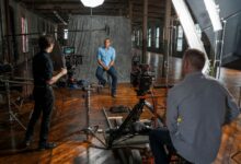 Film crew recording an interview in a Miami studio with professional equipment and lighting.