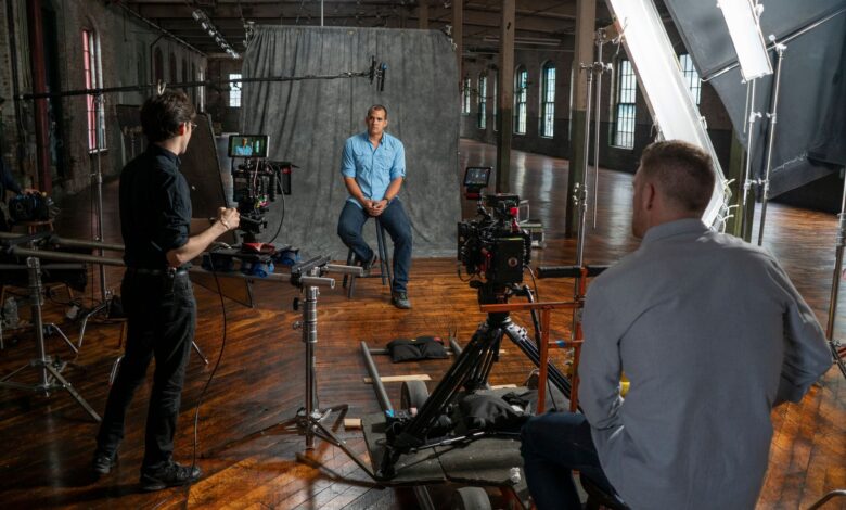 Film crew recording an interview in a Miami studio with professional equipment and lighting.