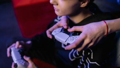 Close-up of teenagers playing video games together using modern game controllers.