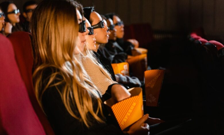 Group of people wearing 3D glasses watching a movie in a cinema, captivated by the film.