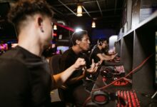 A group of young men intensely engaged in a competitive gaming session at an esports venue.