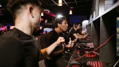 A group of young men intensely engaged in a competitive gaming session at an esports venue.