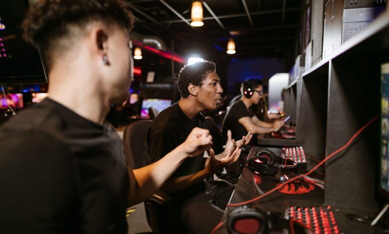 A group of young men intensely engaged in a competitive gaming session at an esports venue.