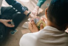 Three children engaged in a strategic card game session, focusing intently on their hands.