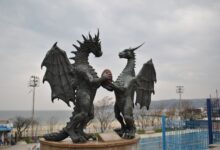 Two majestic dragon statues facing each other by the seaside.