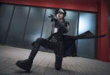 A young adult in striking cosplay attire poses dramatically indoors, embodying fantasy and role-playing themes.