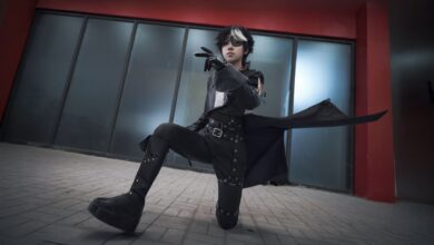 A young adult in striking cosplay attire poses dramatically indoors, embodying fantasy and role-playing themes.