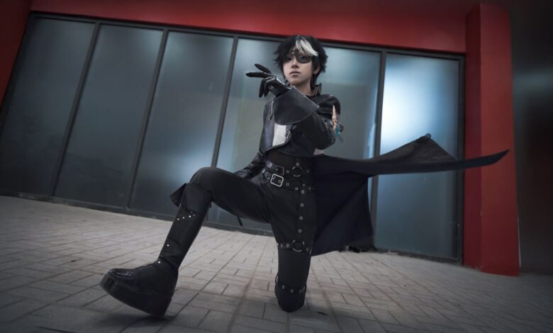 A young adult in striking cosplay attire poses dramatically indoors, embodying fantasy and role-playing themes.