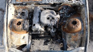 Aerial view of a burnt-out engine in an abandoned car, showcasing rust and decay.