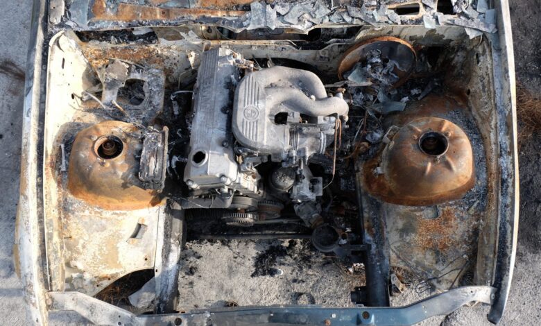 Aerial view of a burnt-out engine in an abandoned car, showcasing rust and decay.