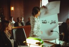 A professional woman presents to a courtroom in Baghdad, Iraq, emphasizing strategy.