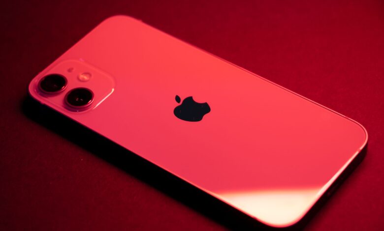 Close-up of a red smartphone with dual lenses on a red backdrop, highlighting sleek design and technology.