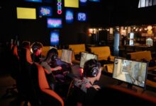 Group of gamers participating in an online tournament at a modern internet cafe.