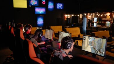 Group of gamers participating in an online tournament at a modern internet cafe.