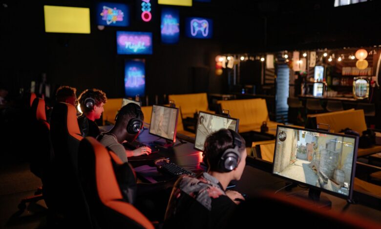 Group of gamers participating in an online tournament at a modern internet cafe.
