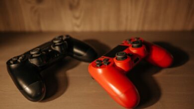Detailed image of red and black game controllers on a wooden surface.