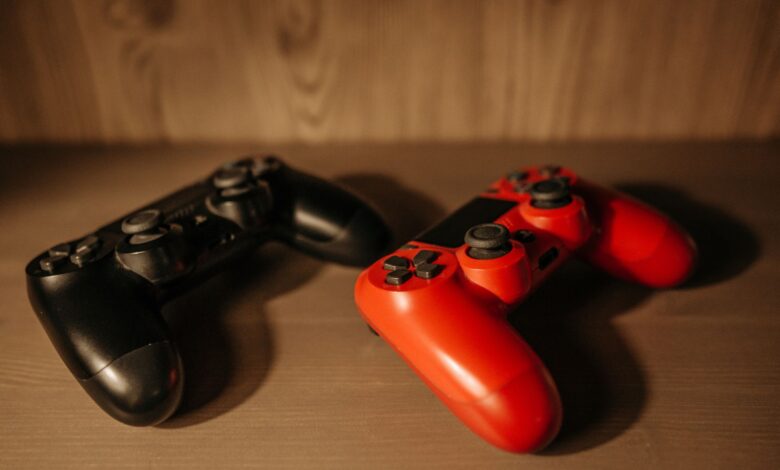Detailed image of red and black game controllers on a wooden surface.