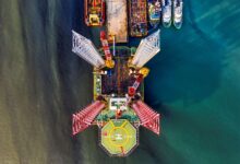 Stunning aerial view of a vibrant offshore oil rig with crane and helipad in Jakarta's waters.