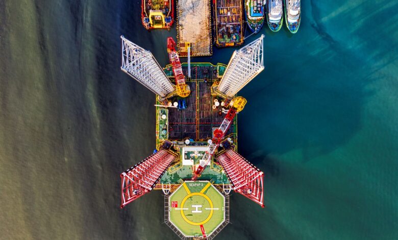 Stunning aerial view of a vibrant offshore oil rig with crane and helipad in Jakarta's waters.
